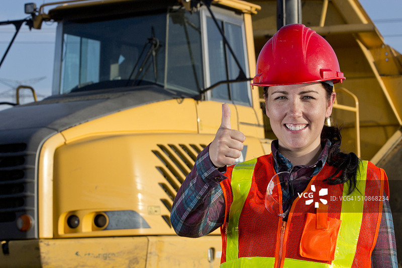 积极的女建筑工人和重型运输卡车图片素材