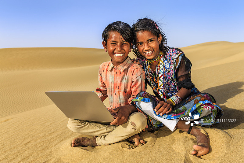 使用笔记本电脑的快乐印度儿童图片素材