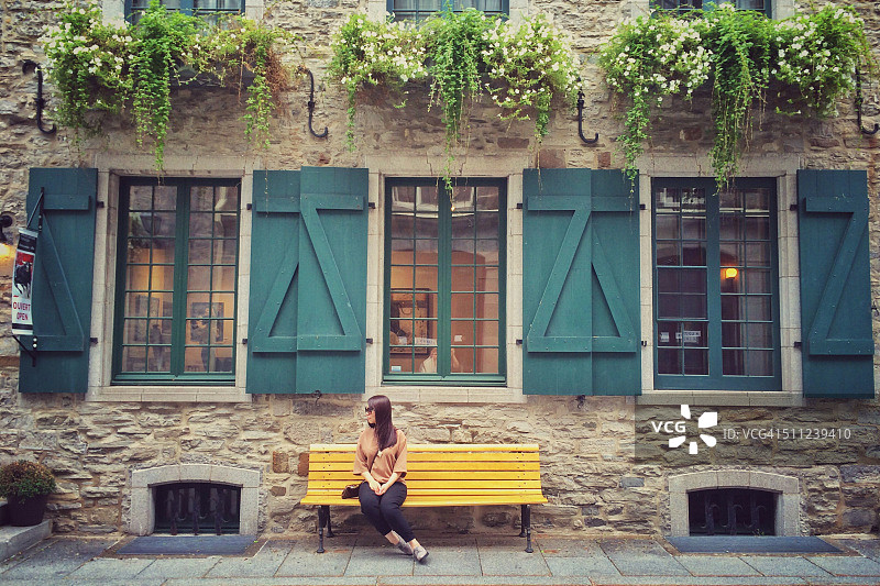 坐在魁北克老城长椅上的女孩图片素材