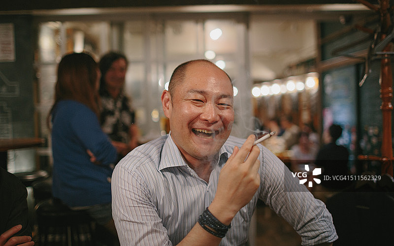 下班后在酒吧吸烟的日本商人图片素材