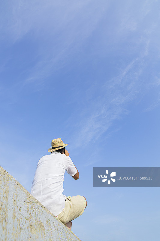 用双筒望远镜观看的年轻男人图片素材
