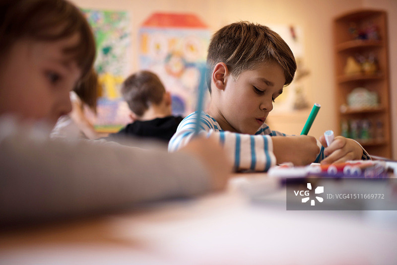 在幼儿园课堂上画画的小男孩图片素材