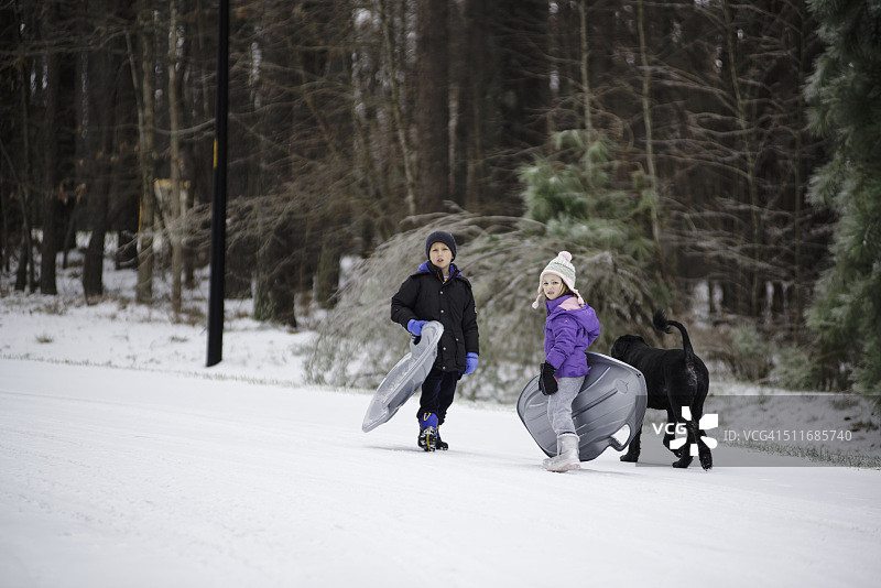 冬天里，小男孩玩雪橇图片素材