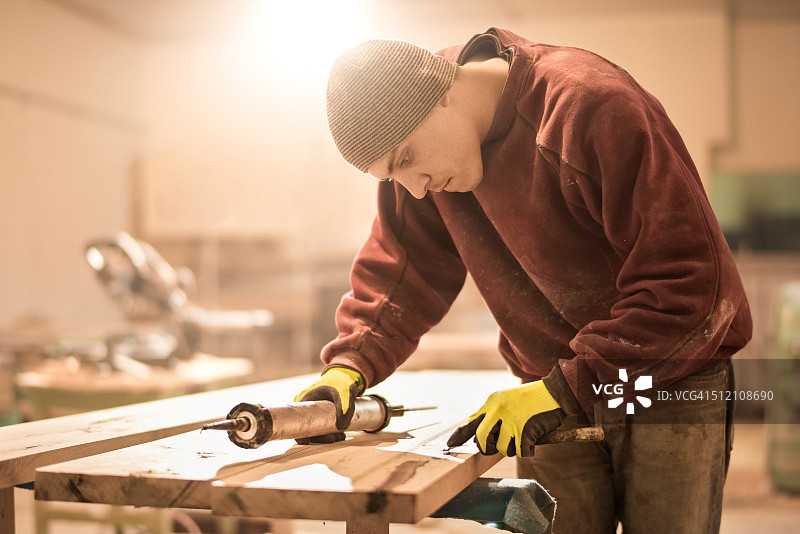 男人在木板上涂胶水图片素材
