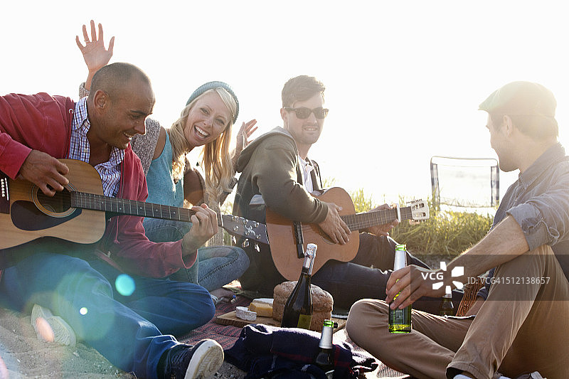 四个成年朋友在英国多塞特郡伯恩茅斯海滩聚会图片素材
