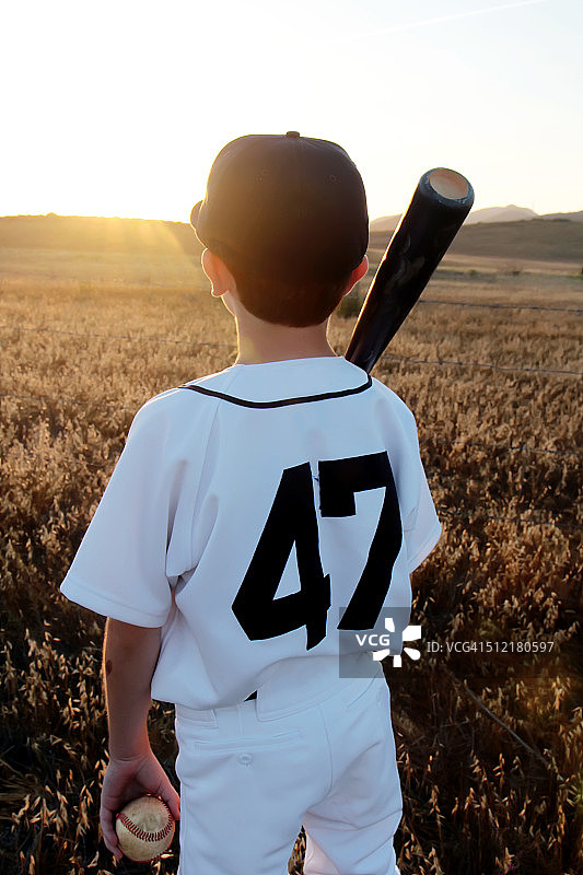 夕阳下的年轻棒球运动员（背影）图片素材