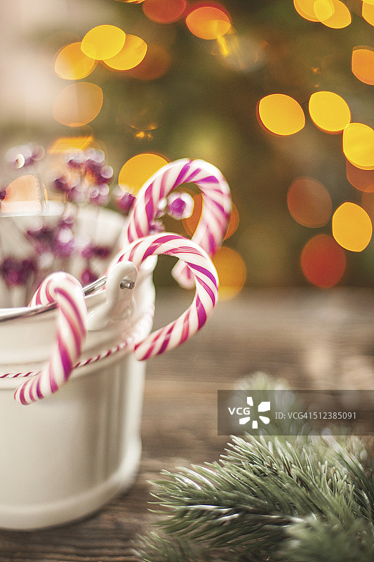 木桌上的白色小桶里的拐杖糖图片素材