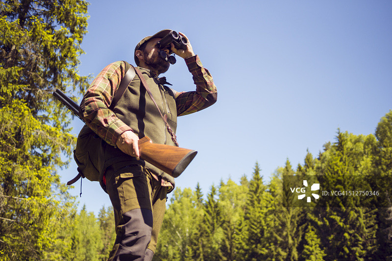 用双筒望远镜观察田野的男人图片素材