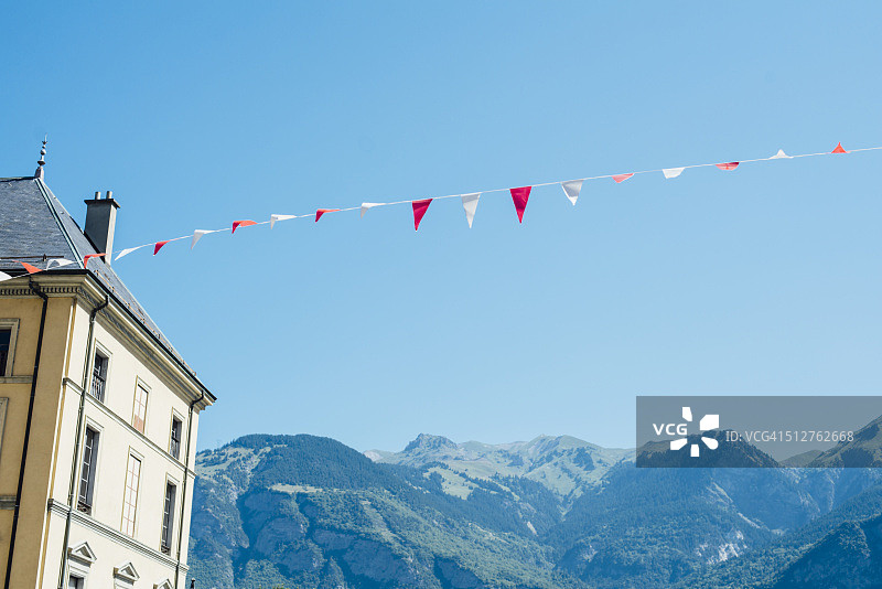 法国圣让德莫里安的房子，为环法自行车赛装饰着红白旗，可欣赏阿尔卑斯山的晴朗夏日景色图片素材