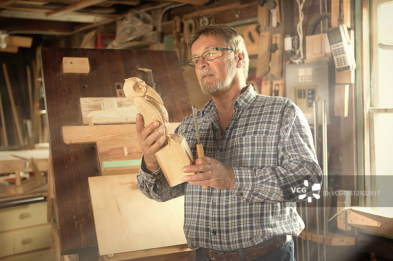 男人看着他雕刻的雕塑图片素材