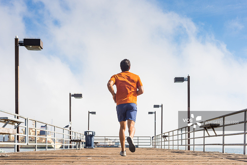 在海洋码头上慢跑的男人图片素材