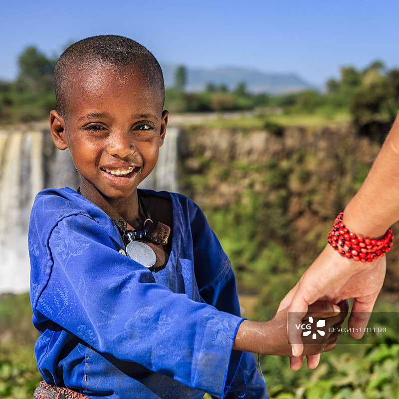 白人女性牵着非洲儿童的手图片素材