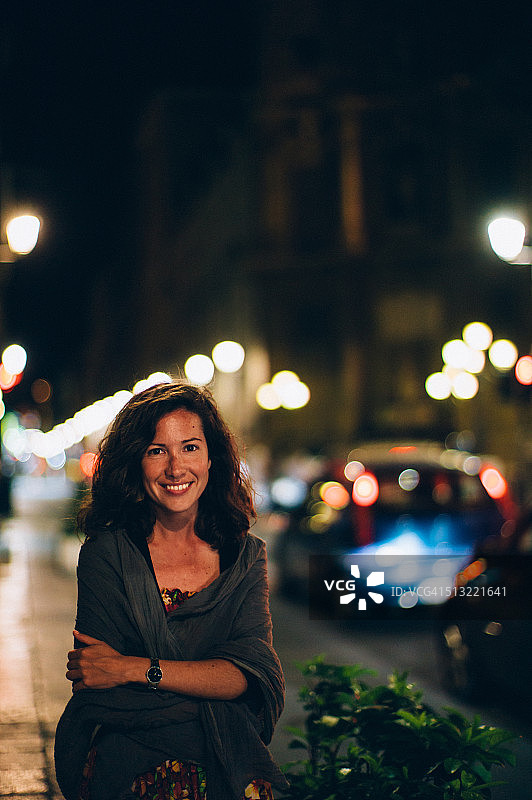 夜晚在街道上的漂亮微笑女人图片素材