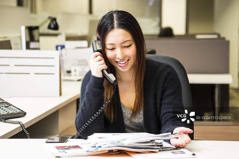 在电话里交谈的微笑办公室工作人员图片素材