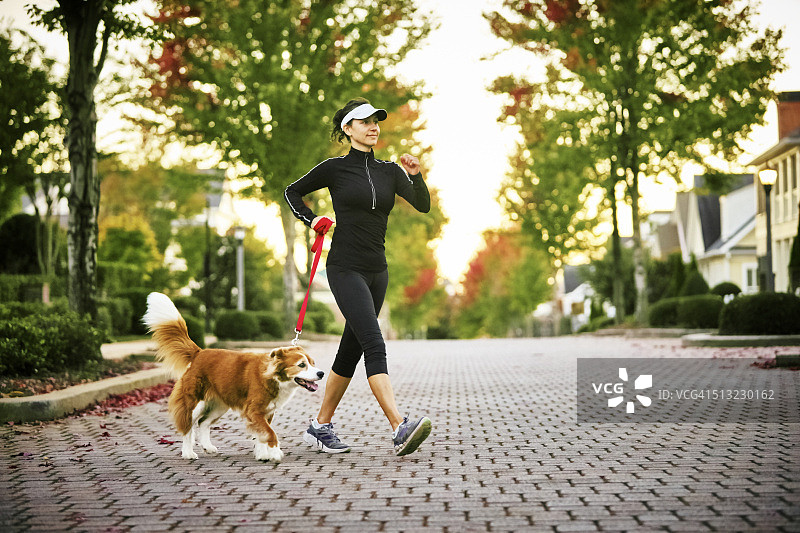 年轻女子遛狗图片素材