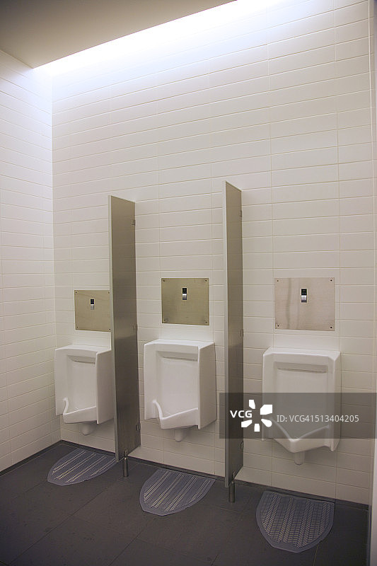 男卫生间带钢制隔板的小便池图片素材