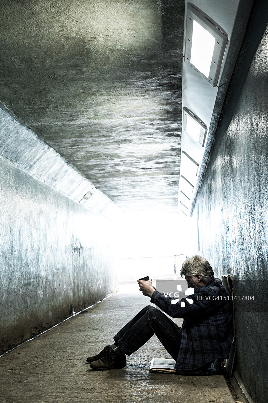 在地铁隧道里乞讨的年长流浪汉图片素材