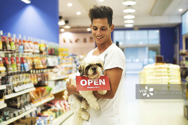 微笑的男人带着狗在宠物店里图片素材