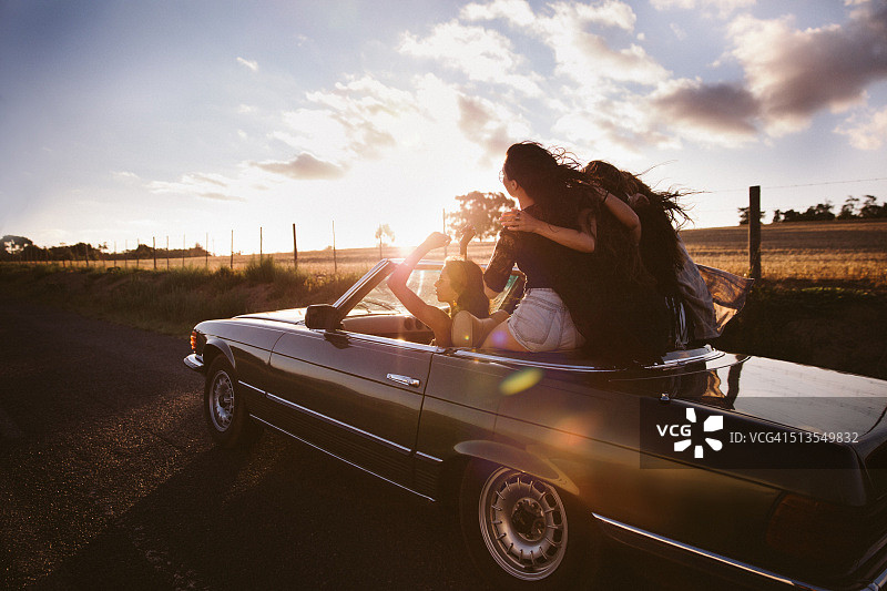 日落时分，在公路旅行中热情拥抱的青少年朋友们图片素材