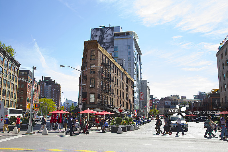 人们在三角形建筑附近穿过街道图片素材