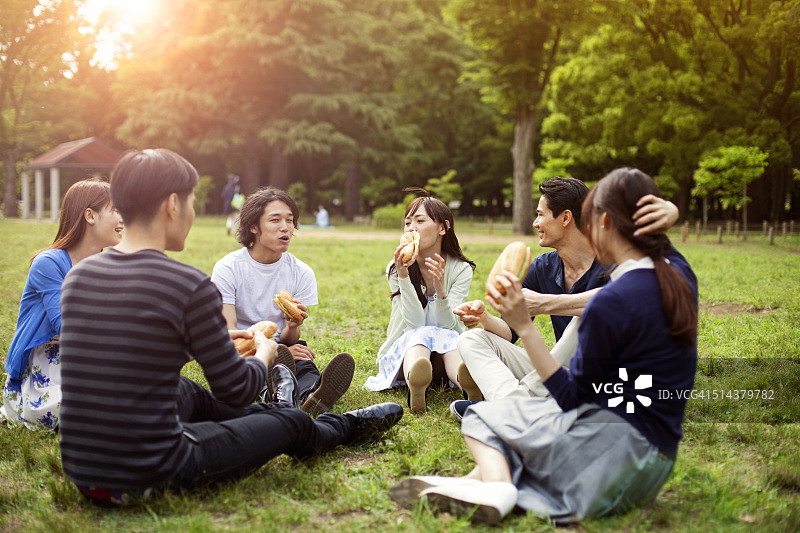 一群快乐的日本朋友在东京的公园里聚餐图片素材