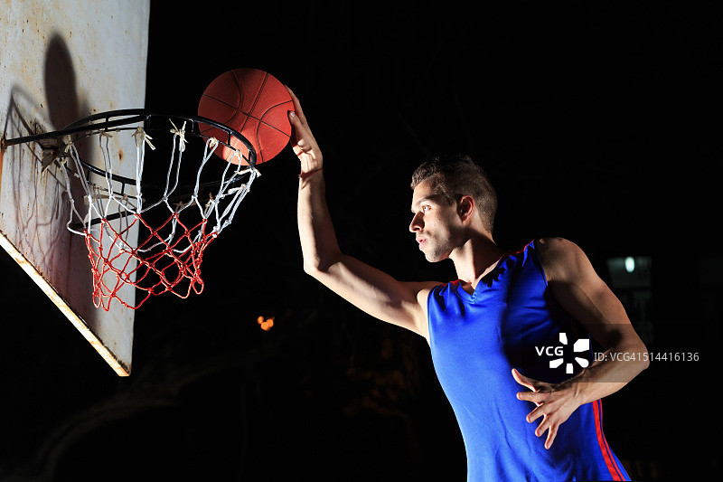 球员在黑色背景上完成扣篮图片素材