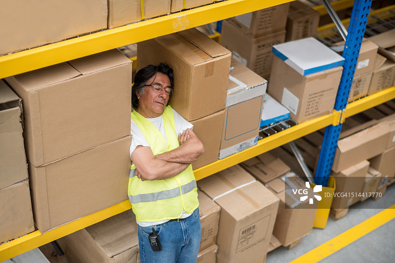 在仓库里睡觉的懒惰工人图片素材