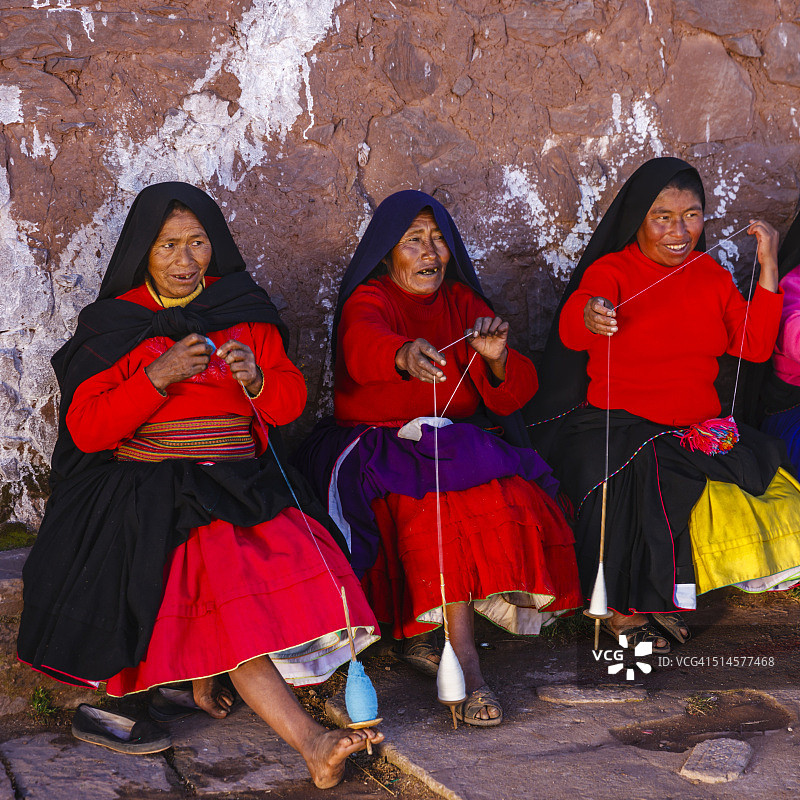 在秘鲁的的喀喀湖塔基勒岛上，妇女在纺羊毛图片素材