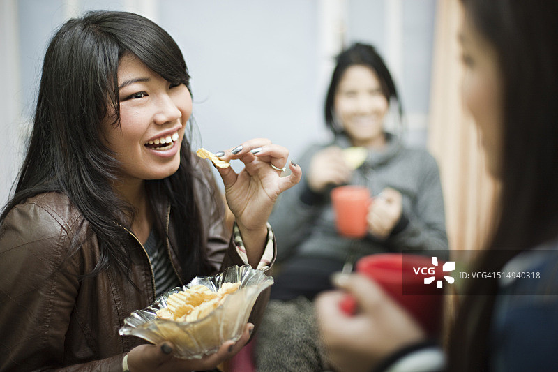 快乐的多种族女性朋友一起享用咖啡和小吃图片素材