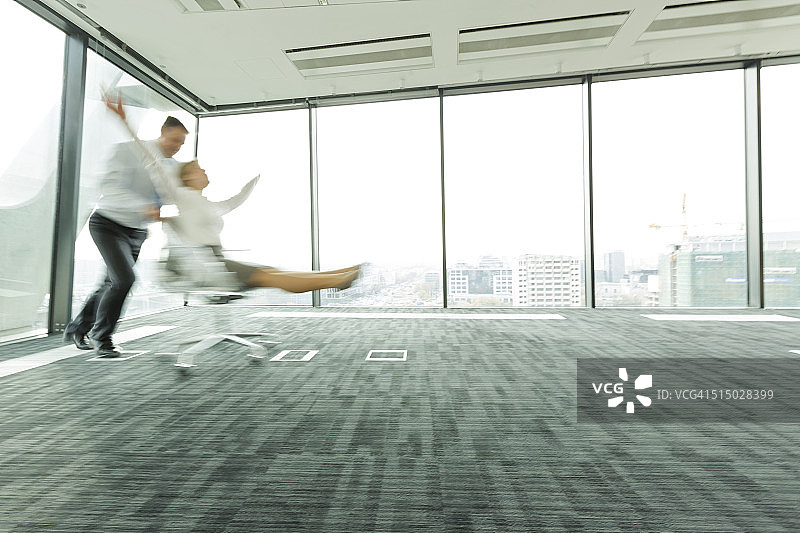 商人推动办公室椅子上的女商人图片素材