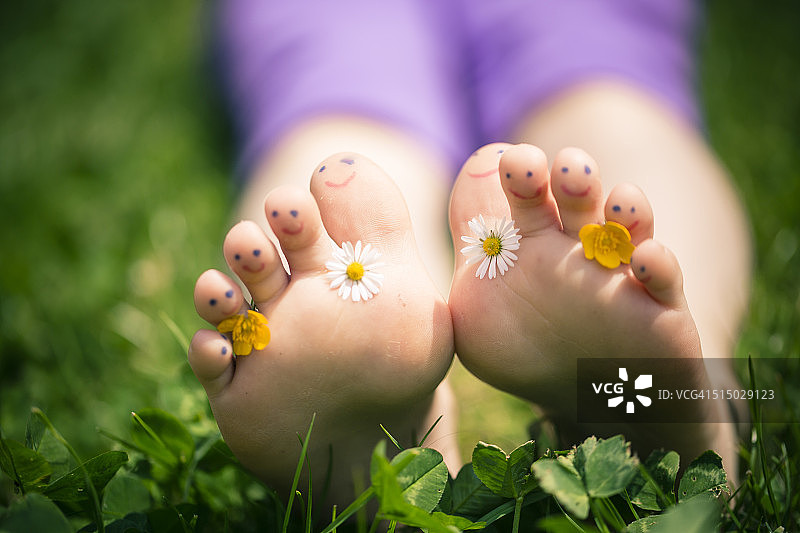 小女孩的脚趾涂有雏菊和毛茛装饰图片素材