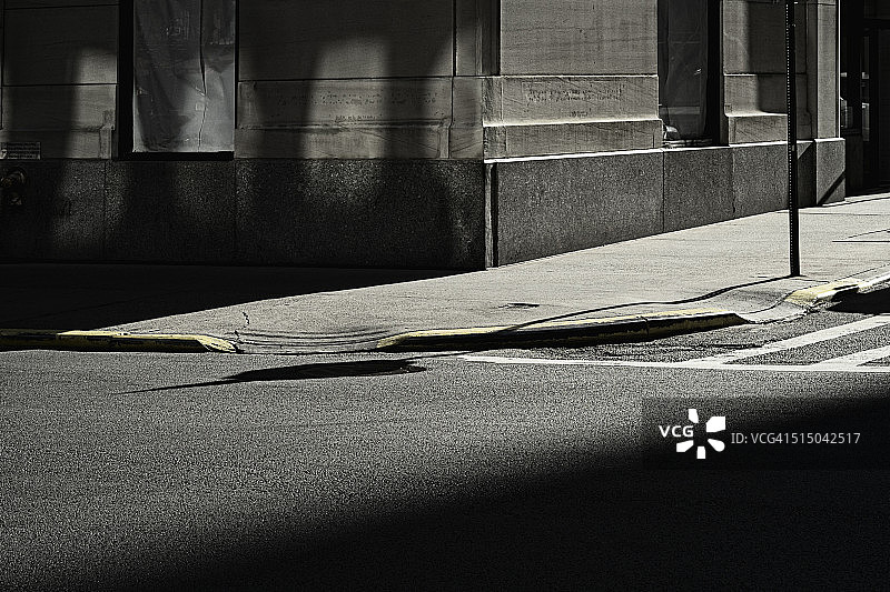 阴影中的道路、人行道和建筑物一角图片素材
