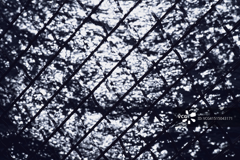 透过铁丝网看到的水面图片素材
