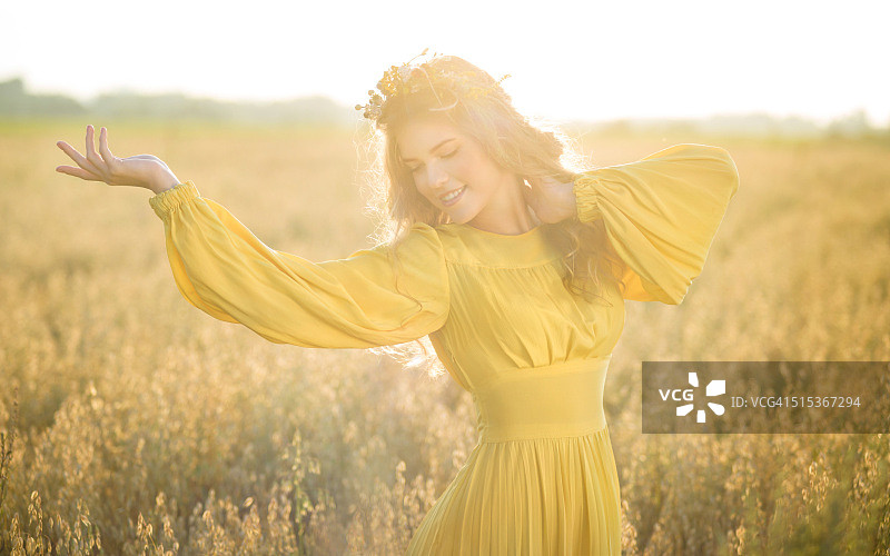阳光下的田野里快乐的女人图片素材