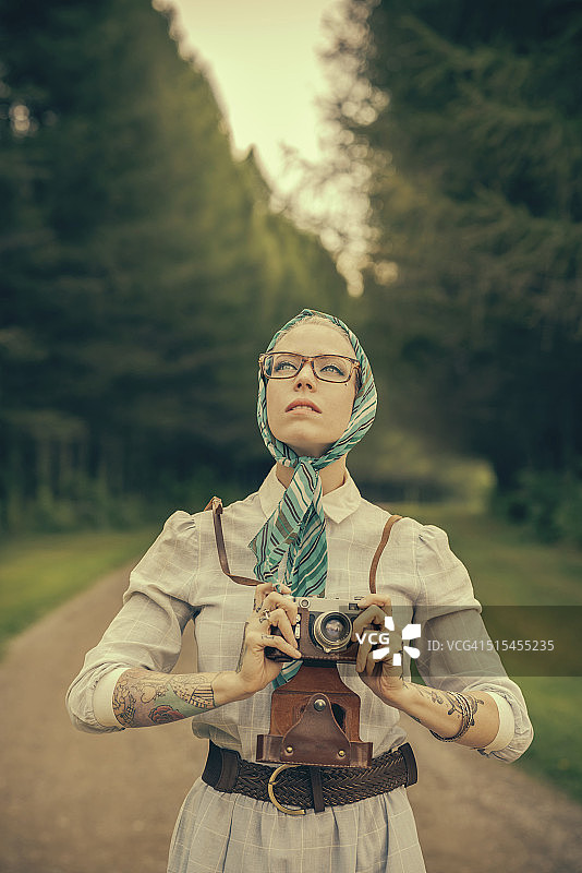 拿着复古测距仪的金发女人图片素材