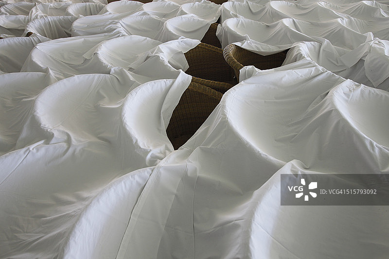 排成一列并盖着白布的扶手椅图片素材