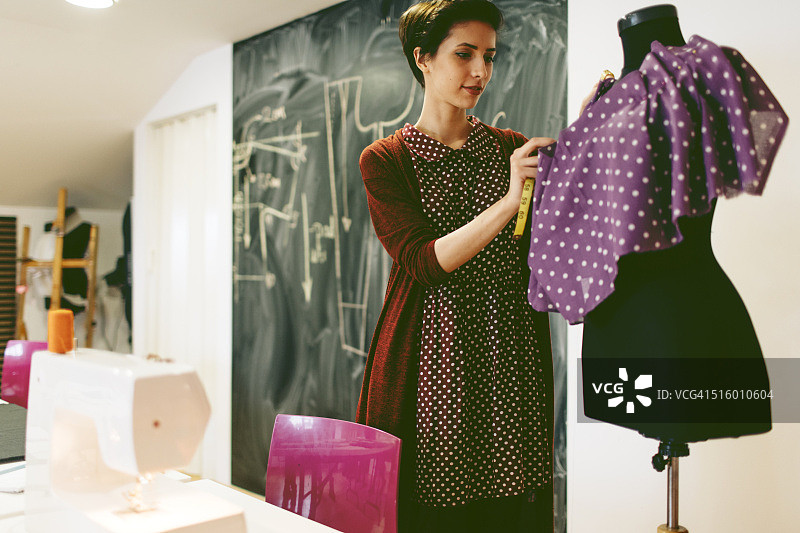 年轻时装设计师在她的工作室工作图片素材