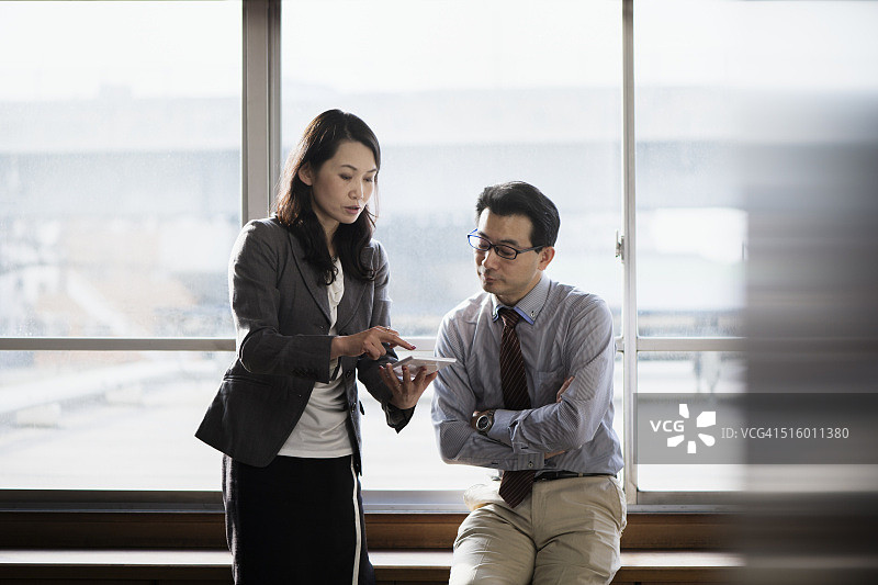 在平板电脑上协同工作的办公室工作人员图片素材