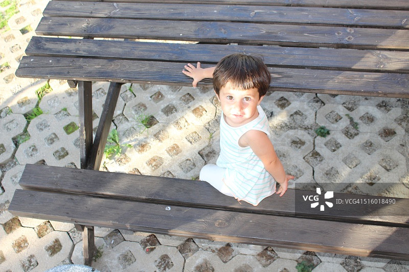 小女孩坐在野餐桌旁图片素材