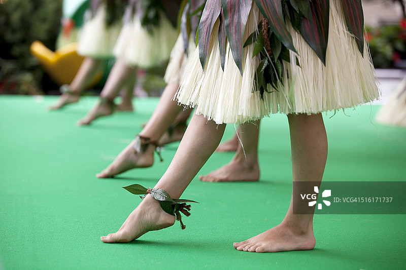 在绿色地毯上跳草裙舞图片素材
