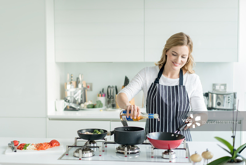 快乐的女人在家做饭图片素材
