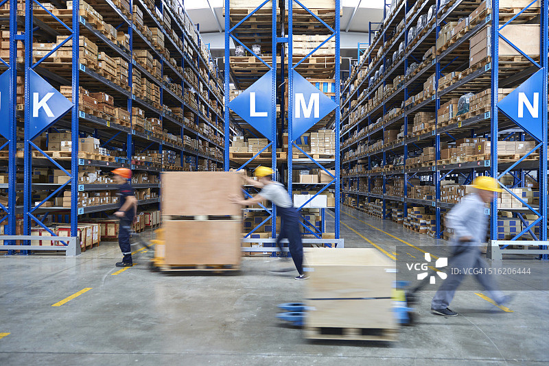在仓库里搬运纸箱的同事图片素材