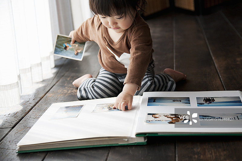 女孩整理相册里的照片图片素材