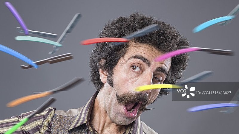 留着把手胡子的男子面对飞来的剃须刀图片素材