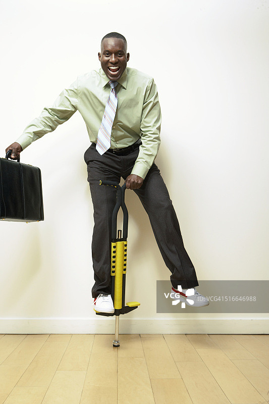 踩弹簧单高跷的商人图片素材