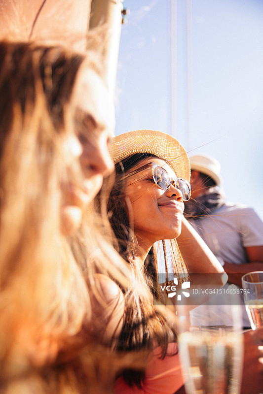 戴帽子和太阳镜的多民族女孩在阳光下参加聚会图片素材