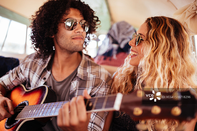 多种族时尚青年在公路旅行中唱歌（带吉他）图片素材