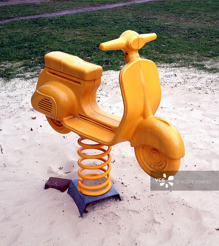 弹簧上的黄色玩具摩托车图片素材