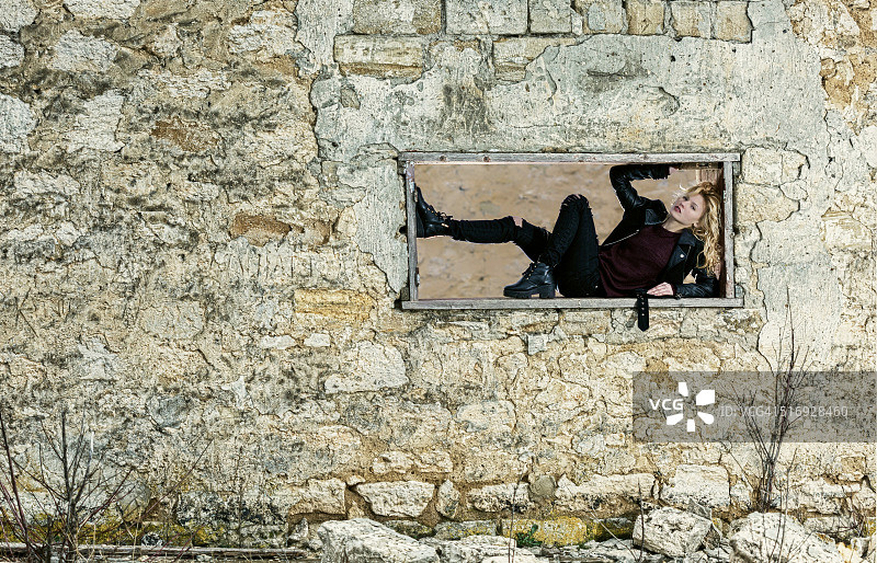 在废弃建筑物窗框中的女孩图片素材
