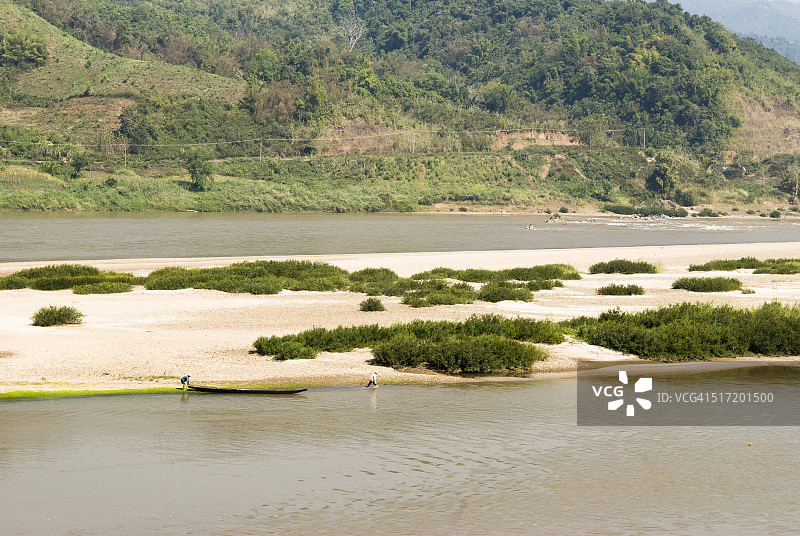 湄公河沙丘上乘坐长尾船的渔民图片素材